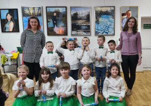 Dzieci po występie, trzymając słodkie upominki pozują z nauczycielkami do pamiątkowego zdjęcia.