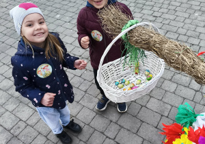 Dzieci wrzucają do koszyczka odnalezione, wielkanocne jajeczka i zajączki z czekolady.