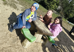 Kilkoro dzieci odpoczywa na ogrodzie przedszkolnym.