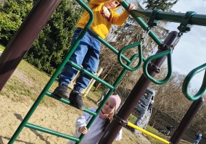 Dzieci wspinają się na drabinki na przedszkolnym placu zabaw.