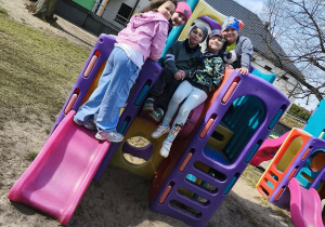 Dzieci na kolorowej konstrukcji na ogrodzie przedszkolnym.