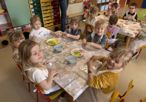 Dzieci z grupy "Wiewiórek" ozdabiają torebki przy pomocy naklejek o tematyce wielkanocnej.