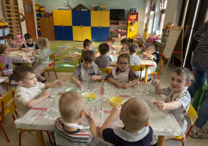 Dzieci z grupy "Wiewiórek" ozdabiają torebki przy pomocy naklejek o tematyce wielkanocnej.