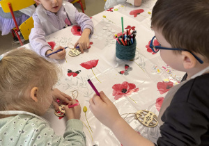 Kolorowanie drewnianych pisanek przy pomocy mazaków wśród dzieci z grupy II.