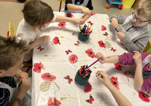 "Motylki" kolorują drewniane pisanki, przy użyciu kolorowych mazaków.