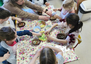 "Pszczółki" przy stole tworzą swoje, czekoladowe pisanki.