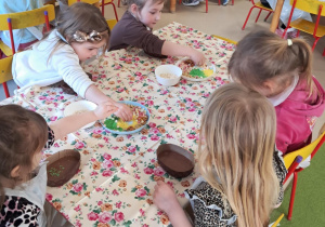 Dzieci z grupy III podczas zdobienia czekoladowych pisanek przy użyciu kolorowych, jadalnych ozdób.