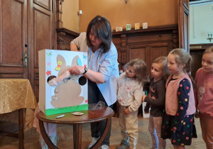 "Żabki" kolejno dodają elementy do wielkanocnego zajączka.