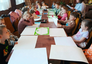 Dzieci z grupy "Motylków" uważnie słuchają cioci Agnieszki w MBP.