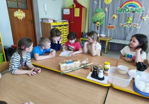 Chętne dzieci odczytują etapy przepisu na zdrową pastę jajeczną.