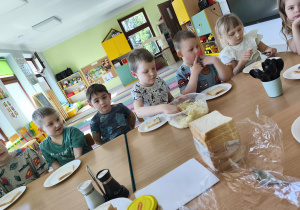 Chętne dzieci nakładają sobie na talerzyk kromkę chleba tostowego oraz przygotowaną pastę jajeczną.