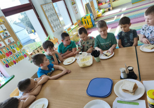 Chętne dzieci nakładają sobie na talerzyk kromkę chleba tostowego oraz przygotowaną pastę jajeczną.