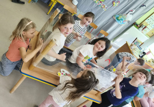 Drugi zespół maluje wiosnę według własnego pomysłu korzystając z folii stretch, farb w wiosennych kolorach i swoich paluszków.