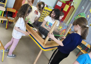 Drugi zespół maluje wiosnę według własnego pomysłu korzystając z folii stretch, farb w wiosennych kolorach i swoich paluszków.