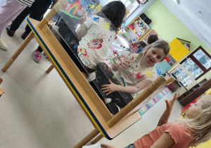 Drugi zespół maluje wiosnę według własnego pomysłu korzystając z folii stretch, farb w wiosennych kolorach i swoich paluszków.