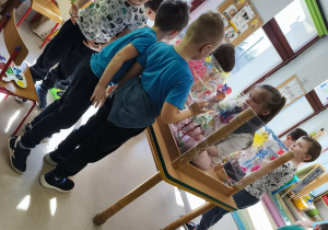 Pierwszy zespół maluje wiosnę według własnego pomysłu korzystając z folii stretch, farb w wiosennych kolorach i swoich paluszków.