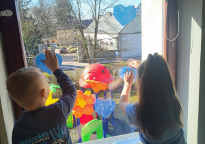 "Pszczółki" przyczepiają swoje niebieskie serduszka na oknach w naszej sali.