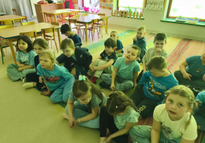 Dzieci z grupy "Pszczółek" siedzą na dywanie i słuchają ważnych informacji nt. autyzmu.