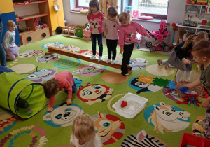 Dzieci pokonują wiosenny tor przeszkód.