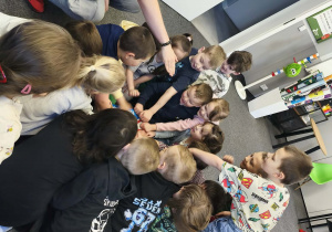 "Pszczółki" pukają do pudełka, w którym ukryła się kolorowa skarpetka i mały miś Teddy Eddie.