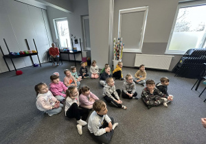 Dzieci z grupy "Motylków" siedzą na dywanie w sali "Fabryki Języka".