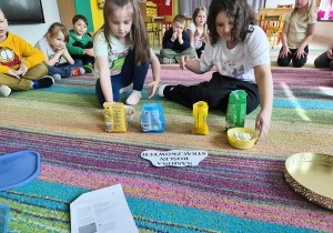 Dziewczyny dopasowują pojemnik z nasionami roślin strączkowych do odpowiedniego opakowania.