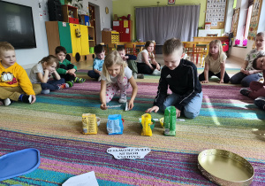 Dzieci dobierają podpisy do poszczególnych opakowań z nasionami roślin strączkowych.