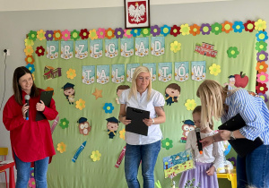 Dziewczynka prezentuje swoją pracę plastyczną.