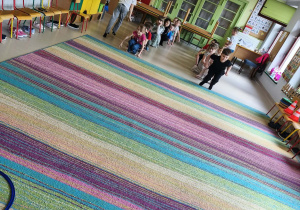 Dzieci biorą udział w konkurencji sportowej "Żabie skoki".