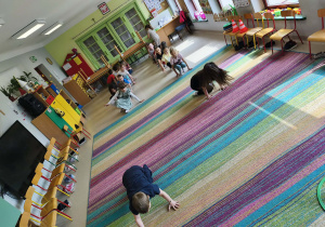 Dzieci biorą udział w konkurencji sportowej "Żabie skoki".