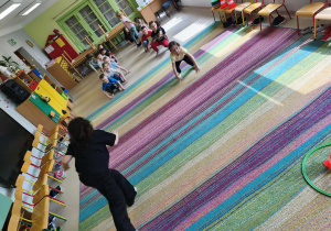 Dzieci biorą udział w konkurencji sportowej "Żabie skoki".