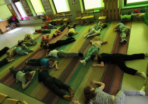 Wyciszenie na dywanie przy muzyce relaksacyjnej, podczas której dzieci ułożyły się w pozycji wybranej przez siebie.