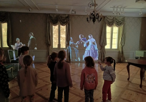 Dziewczynki zwiedzają Muzeum Pałacu Saskiego w Kutnie, słuchając opowieści przewodniczki.