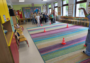 Udział dzieci podzielonych na drużyny w zabawie ruchowej "Uratuj jabłka przed zamrnowaniem".