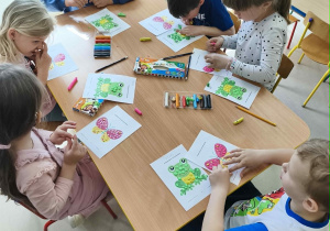 Wyklejamy szablon motylków/żabek za pomocą kulek z plasteliny.