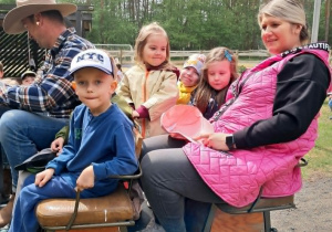 Kilkoro dzieci podczas przejażdżki bryczką zaprzegniętą w kucyka.