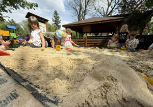 Dzieci tworzą swoje piaskowe budowle.