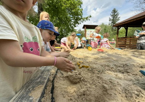 Dzieci tworzą swoje piaskowe budowle.