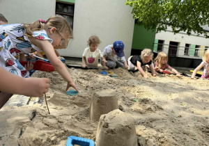 Dzieci tworzą swoje piaskowe budowle.