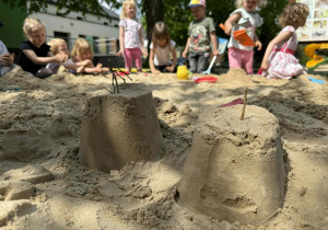 Dzieci tworzą swoje piaskowe budowle.
