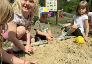 Dzieci tworzą swoje piaskowe budowle.