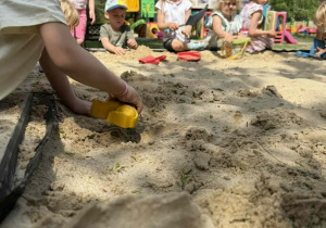 Dzieci tworzą swoje piaskowe budowle.