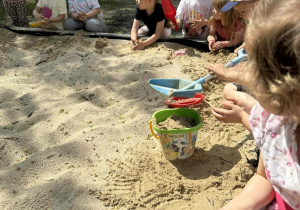Dzieci tworzą swoje piaskowe budowle.