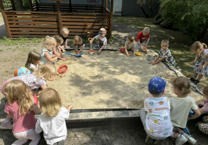 Dzieci tworzą swoje piaskowe budowle.