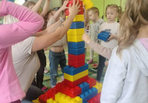 Dzieci budują z klocków piramidę.
