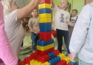 Dzieci budują z klocków piramidę.