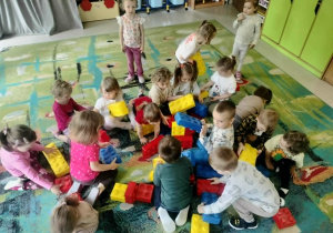 Dzieci budują z klocków piramidę.