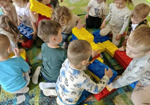 Dzieci budują z klocków piramidę.