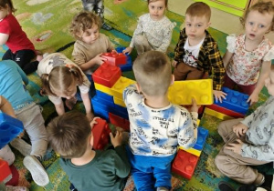 Dzieci budują z klocków piramidę.