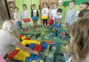 Dzieci budują z klocków piramidę.